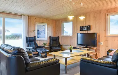 a living room with leather furniture and a flat screen tv at Holiday Home Bjergehusvej in Harboør