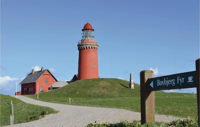 a lighthouse on top of a hill with a street sign at Holiday Home Bjergehusvej in Harboør
