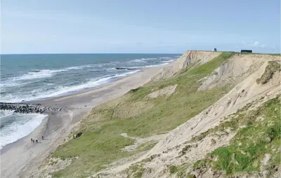 a view of a beach next to a cliff at Holiday Home Bjergehusvej in Harboør