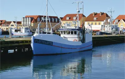 a boat is docked in a harbor with houses at Holiday Home Bjergehusvej in Harboør