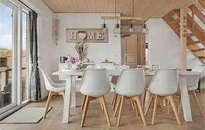 a dining room with a white table and chairs at Holiday Home Doblervej Harboøre X in Harboør