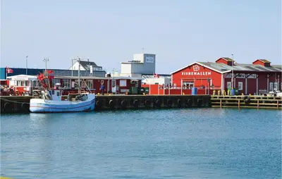a boat docked at a dock in a harbor at Holiday Home Doblervej Harboøre X in Harboør