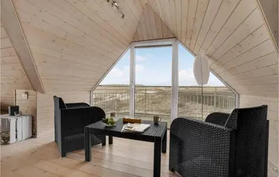 a room with a table and chairs and a large window at Holiday Home Doblervej Harboøre X in Harboør