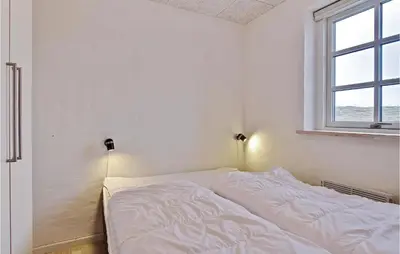 a white bed in a room with a window at Holiday Home Doblervej Harboøre Denm in Harboør