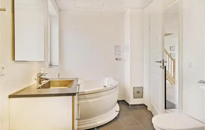 a white bathroom with a sink and a toilet at Holiday Home Doblervej Harboøre Denm in Harboør