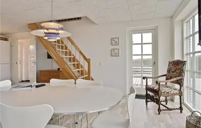 a white dining room with a white table and chairs at Holiday Home Doblervej Harboøre Denm in Harboør