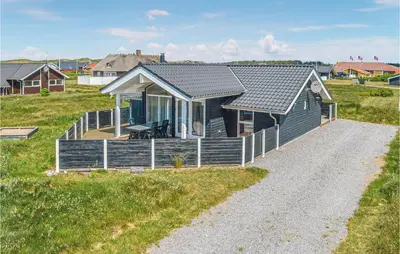 a small house on the side of a field at Frk Lyng in Harboør