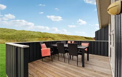 a patio with a table and chairs on a deck at Holiday Home Arcticvej Harboøre Iv in Harboør