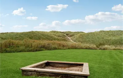 a wooden box in a field of green grass at Holiday Home Arcticvej Harboøre Iv in Harboør