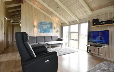 a living room with a couch and a television at Holiday Home Arcticvej Harboøre Iv in Harboør