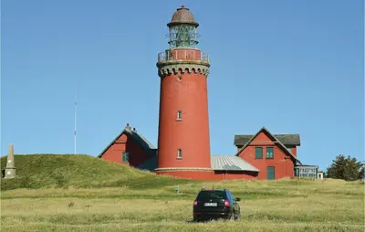 a car parked in front of a red lighthouse at Holiday Home Arcticvej Harboøre Iv in Harboør