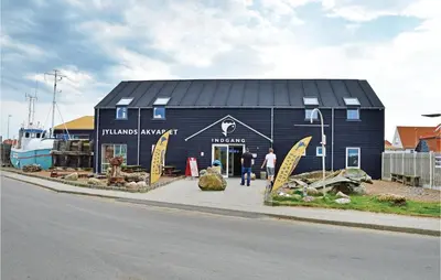 a blue building with surfboards on the side of it at Holiday Home Arcticvej Harboøre Iv in Harboør
