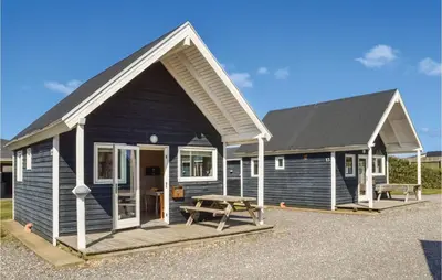 a blue house with a picnic table in front of it at Hytte 6 in Thyborøn