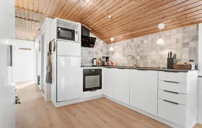 a kitchen with white appliances and a wooden ceiling at Holiday Home Kristinesvej Xii in Thisted