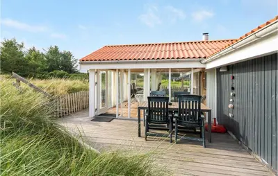 a wooden deck with a table and chairs on it at Holiday Home Kristinesvej Xii in Thisted