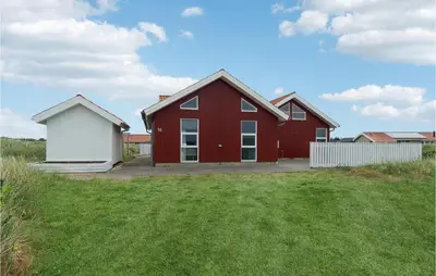 a red house with a white shed in a yard at Stunning Home In Thisted With Sauna in Thisted