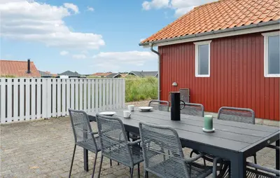 a table and chairs on a patio with a red building at Stunning Home In Thisted With Sauna in Thisted