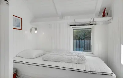 a bed in a white room with a window at Åbo in Thisted
