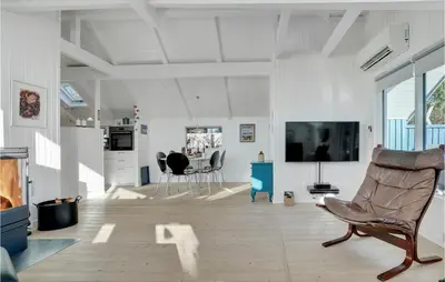 a living room with a television and a chair at Åbo in Thisted