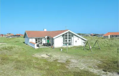 a small white house in the middle of a field at Nice Home In Thisted With Sauna in Thisted