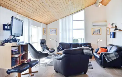 a living room with two chairs and a tv at Nice Home In Thisted With Sauna in Thisted