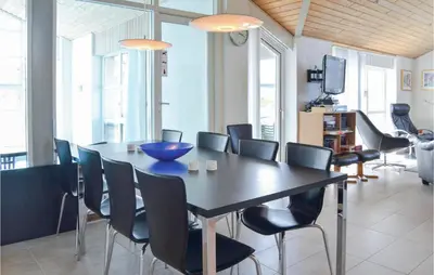 a dining room with a black table and chairs at Nice Home In Thisted With Sauna in Thisted