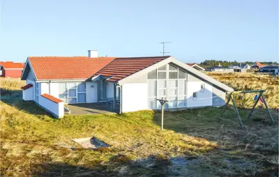 a small house on a hill next to a field at Nice Home In Thisted With Sauna in Thisted