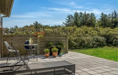 a patio with a table and chairs and plants at Holiday Home Clemmessti in Thisted