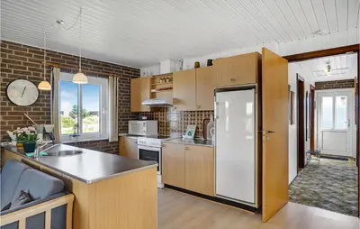 a kitchen with wooden cabinets and a counter top at Holiday Home Clemmessti in Thisted