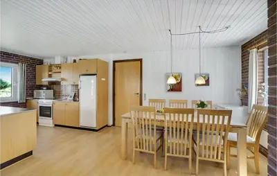 a kitchen and dining room with a table and chairs at Holiday Home Clemmessti in Thisted
