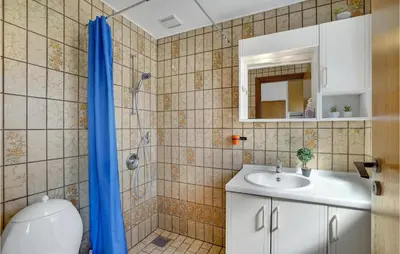 a bathroom with a shower and a sink and a toilet at Holiday Home Clemmessti in Thisted