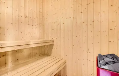 a wooden sauna with a bench and a trash can at Holiday Home Hannesvej V in Vestervig