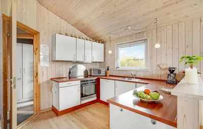 a kitchen with white cabinets and a bowl of fruit on a counter at Holiday Home Hannesvej V in Vestervig
