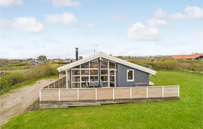 a house with a large deck on a grass field at Holiday Home Hannesvej V in Vestervig