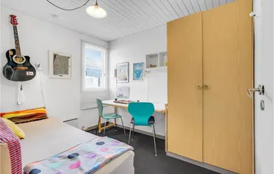 a bedroom with a desk and a bed and a guitar at Holiday Home Havnevej in Vestervig