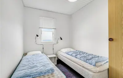 two beds in a small room with a window at Holiday Home Havnevej in Vestervig