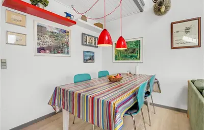 a dining room table with chairs and a colorful table cloth at Holiday Home Havnevej in Vestervig