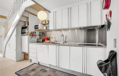 a kitchen with white cabinets and a sink at Holiday Home Havnevej in Vestervig