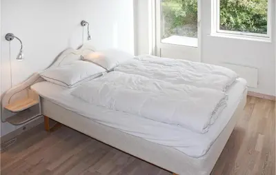 a bed with white sheets and pillows in a bedroom at Holiday Home Sivsangervej Vestervig X in Vestervig