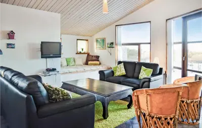 a living room with leather furniture and a tv at Holiday Home Hellesvej Vestervig Denm in Vestervig