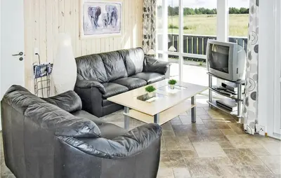 a living room with a leather couch and a tv at Holiday Home Søtungevej in Thisted