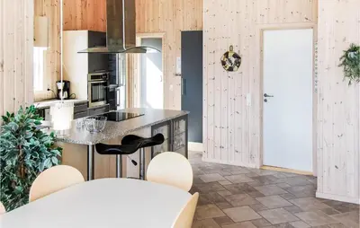a kitchen with a counter and a island with stools at Holiday Home Søtungevej in Thisted
