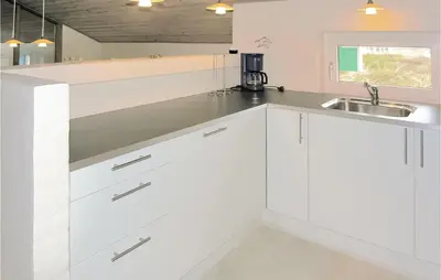 a kitchen with white cabinets and a sink at Holiday Home Klitstien Ii in Thisted