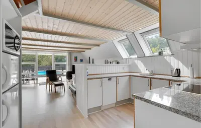 a kitchen with white cabinets and a dining room at Nice Home In Vestervig With Wifi in Vestervig