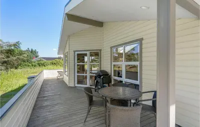 a wooden deck with a table and chairs on a house at Holiday Home Kristinesvej Thisted Vi in Thisted