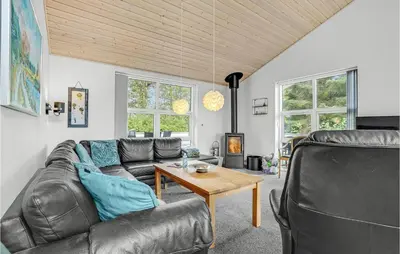 a living room with a leather couch and a table at Holiday Home Kristinesvej Thisted Vi in Thisted