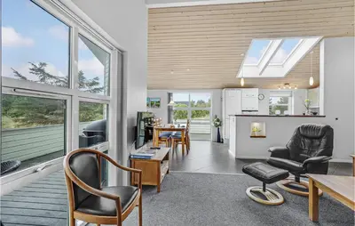 a kitchen and living room with a table and chairs at Holiday Home Kristinesvej Thisted Vi in Thisted