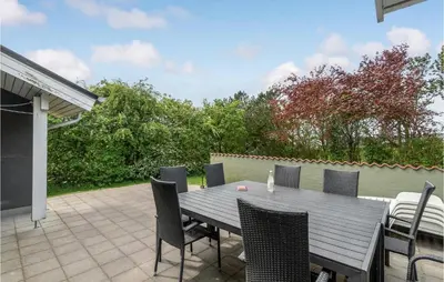 a wooden table and chairs on a patio at 4 Bedroom Lovely Home In Vestervig in Vestervig