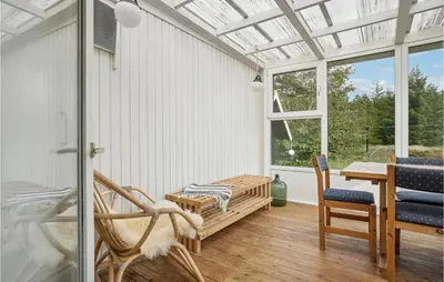 a conservatory with a table and chairs and a window at Holiday Home Mølgårdsvej Thisted in Thisted