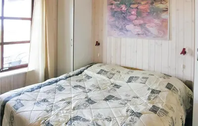 a bed with a quilt on it in a bedroom at Casa Blanca in Thisted
